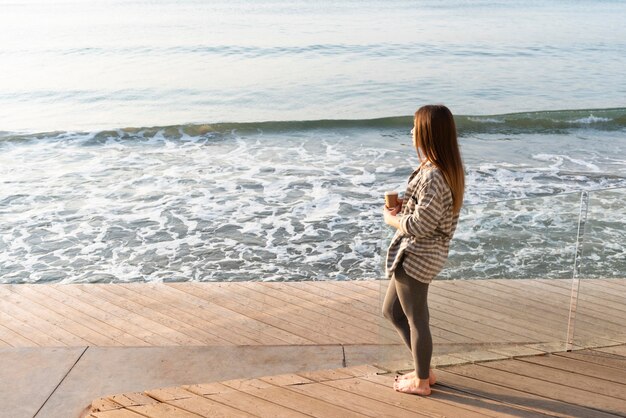 Mujer mirando al mar con espacio de copia