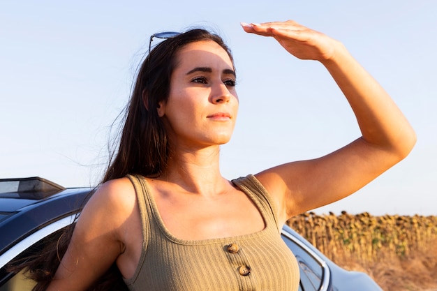 Foto gratuita mujer mirando al sol mientras disfruta de la naturaleza