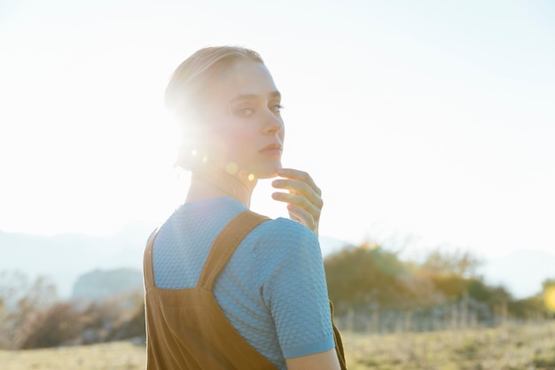 Mujer mirando hacia atrás sobre el hombro con luz solar