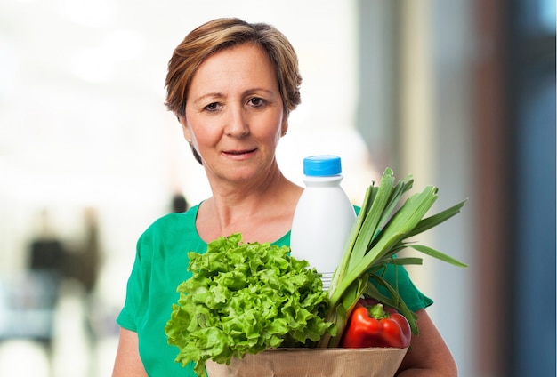 Mujer mirando bol con verduras y leche