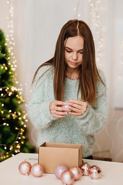 Mujer mirando bolas de árbol decorativas