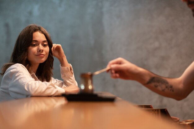 Mujer mirando café en una olla en el bar