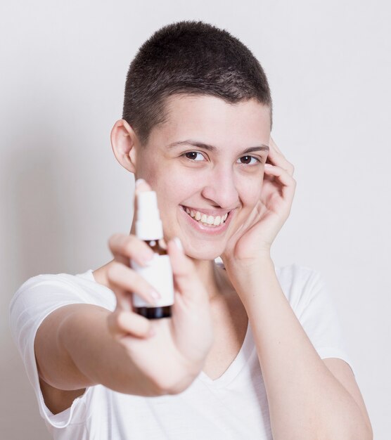 Mujer mirando a cámara con producto de piel en mano