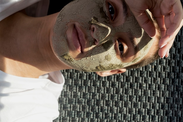 Mujer mirando a cámara con tratamiento de barro facial