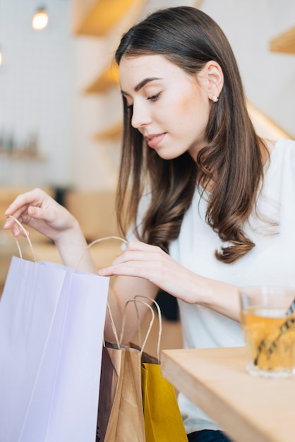 Mujer mirando compras en café