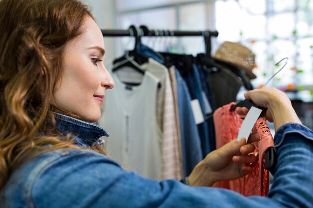 Una mujer mirando la etiqueta de precio de vestir