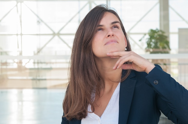 Foto gratuita mujer mirando a un lado, reflexionando, sosteniendo la tableta en la mano