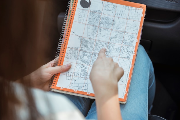 Mujer mirando a mapa en coche