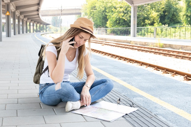 Mujer mirando en un mapa en una estación de tren