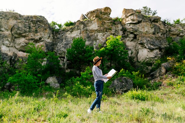 Mujer mirando a mapa en la naturaleza