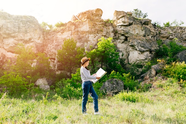 Mujer mirando a mapa en la naturaleza