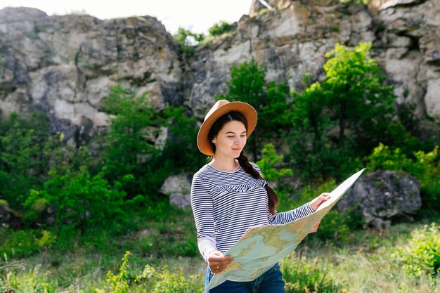 Mujer mirando a mapa en la naturaleza