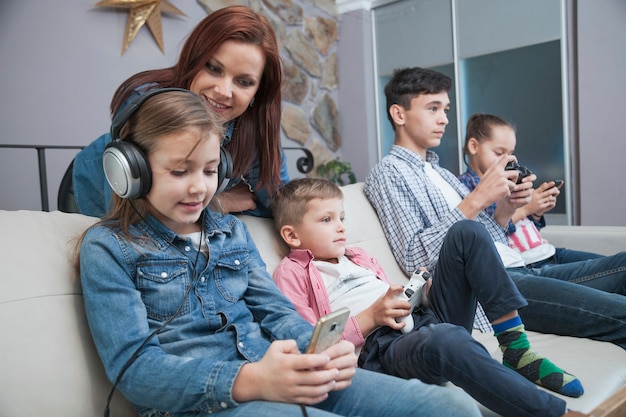 Mujer mirando a los niños jugando videojuegos