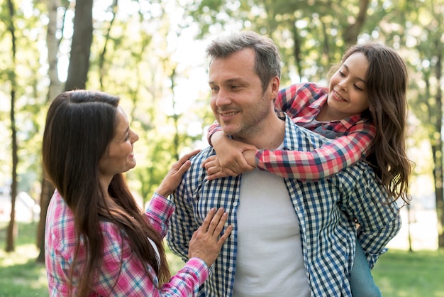 Mujer mirando a su marido con su hija en el parque