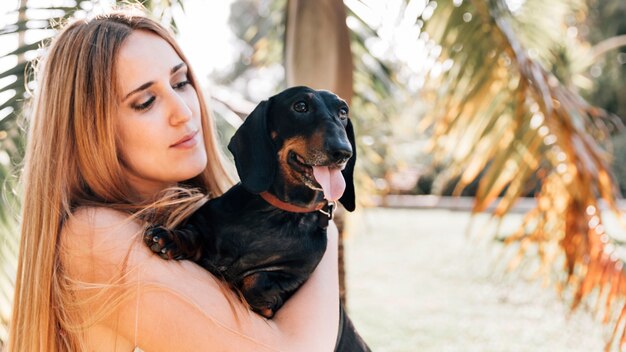 Mujer mirando a su perro sacando la lengua