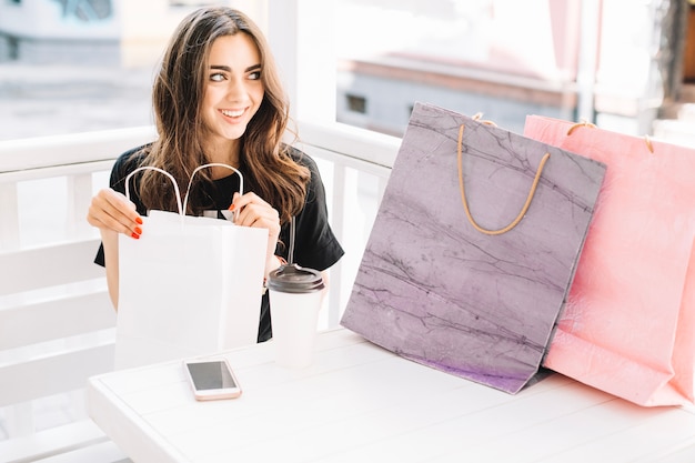 Mujer mirando sus compras en la cafetería