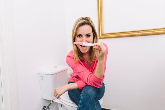 Foto gratuita mujer mirando a test de embarazo en baño