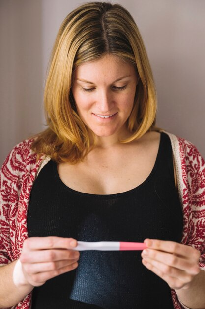 Mujer mirando a test de embarazo