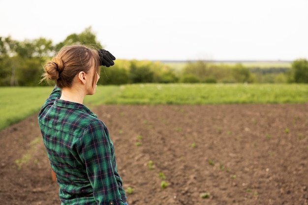 Foto gratuita mujer mirando una tierra de cultivo