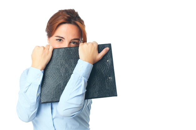 Una mujer mirando tímida detrás de una carpeta negro