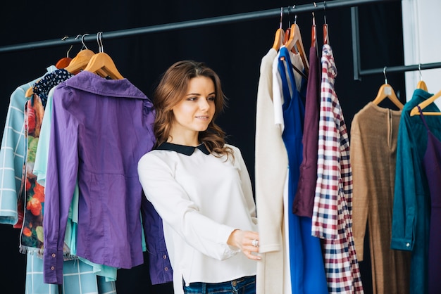 Mujer mirando vestidos en el carril de la ropa