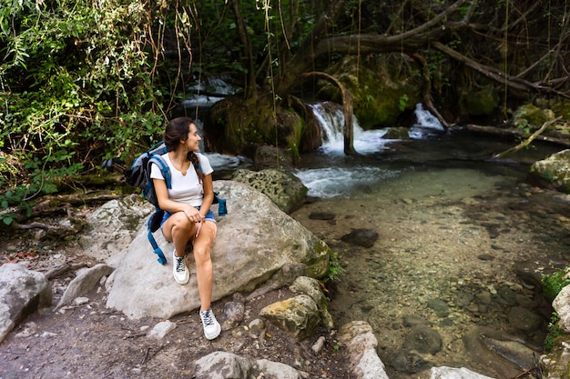 Foto gratuita mujer con mochila admirando y explorando la naturaleza