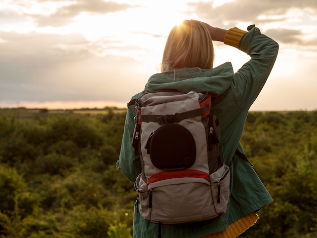 Foto gratuita mujer con mochila al atardecer viajando