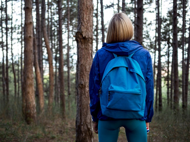 Mujer con mochila en bosque