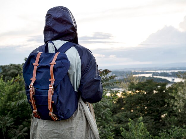 Mujer con mochila en la cima de la montaña