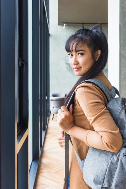 Mujer con mochila en jersey beige.