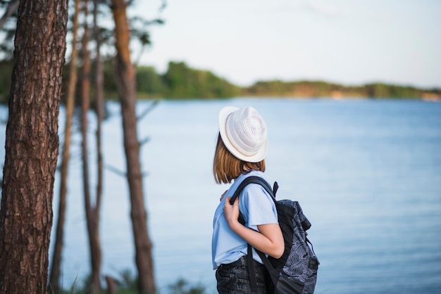 Mujer con mochila mirando el lago