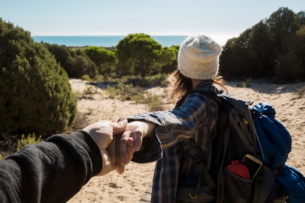 Mujer con mochila que conduce a la playa