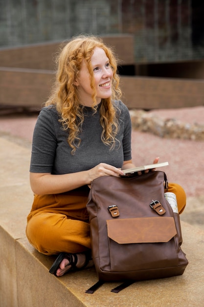 Mujer, con, mochila, tenencia, diario