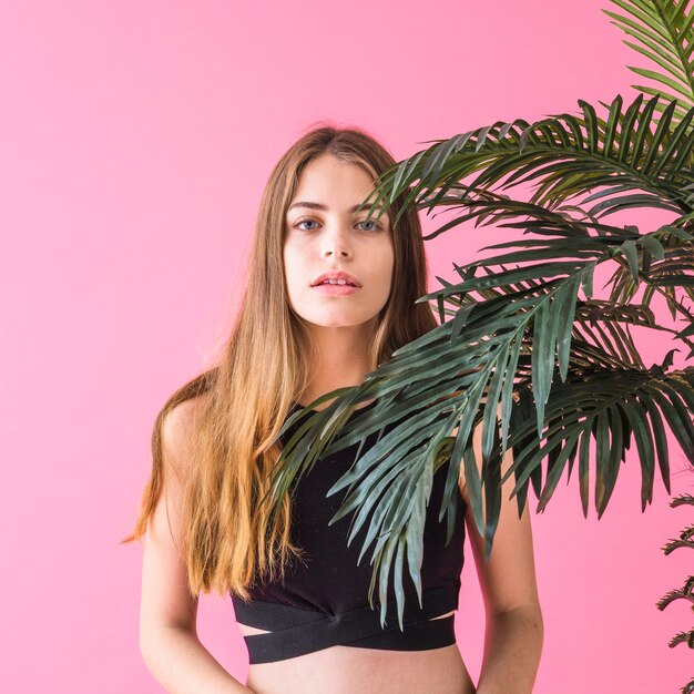 Mujer de moda al lado de palmera