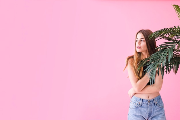 Mujer de moda al lado de palmera