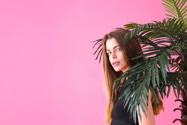 Mujer de moda al lado de palmera