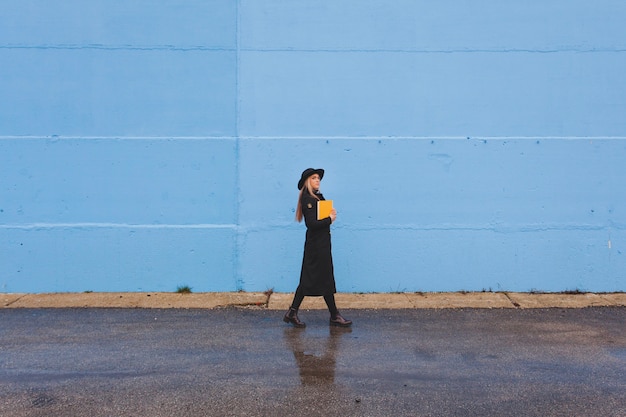 Mujer de moda enfrente de un muro azul