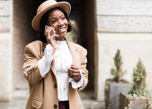 Mujer de moda sonriente hablando por teléfono