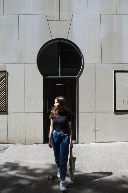 Mujer de la moda de tiro largo con una bolsa de compras