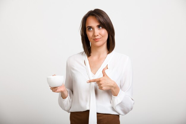 Mujer de moda tomando café en la oficina, hablar con el compañero de trabajo