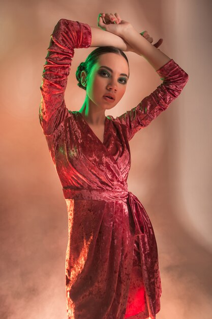 Mujer modelo de alta moda en coloridas luces brillantes posando en studio