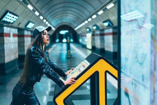 Mujer de modelo de estilo de moda posando en la estación de metro