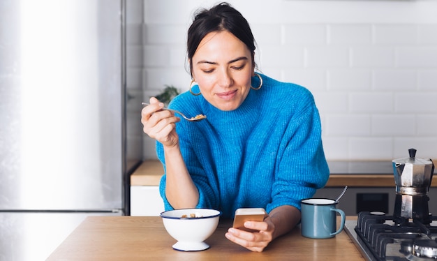 Foto gratuita mujer moderna desayunando en la cocina