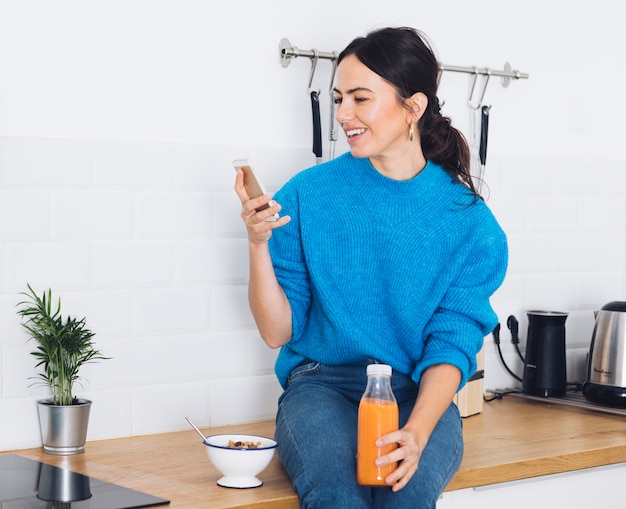 Mujer moderna desayunando en la cocina