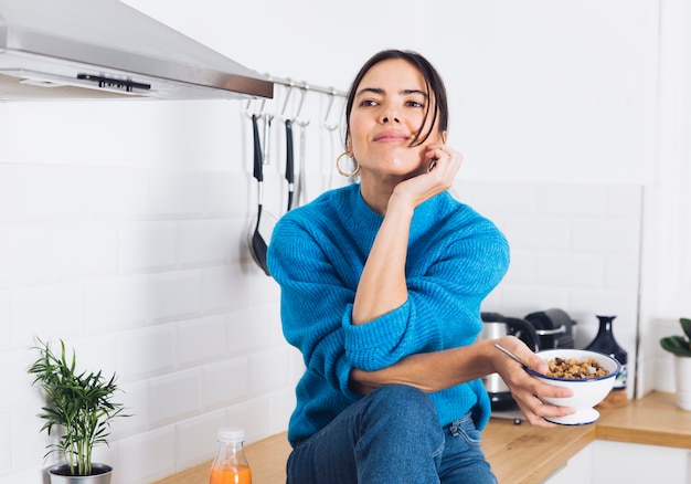 Mujer moderna desayunando en la cocina