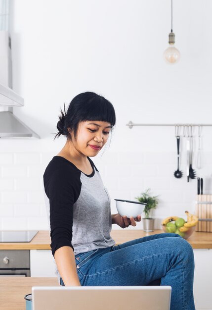 Mujer moderna desayunando en la cocina