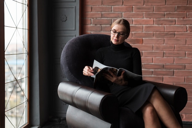 Foto gratuita mujer moderna descansando en el sofá con la revista