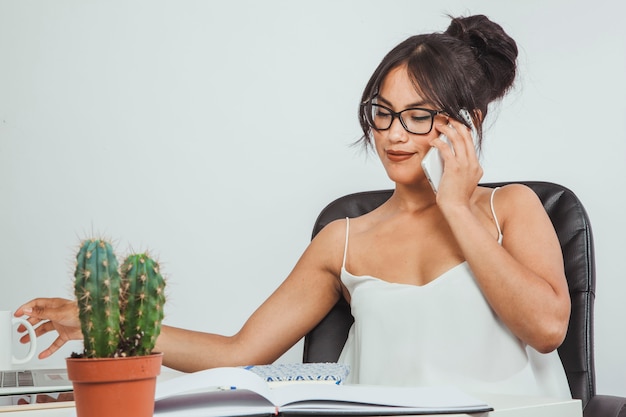 Mujer moderna hablando por teléfono en la oficina