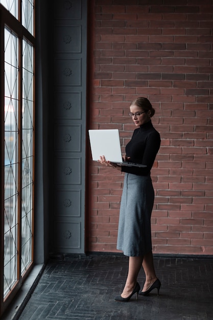 Foto gratuita mujer moderna con laptop trabajando