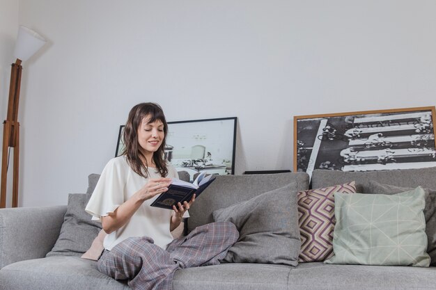 Mujer moderna leyendo en sofá